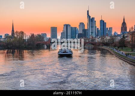 Le centre financier et d'affaires de Francfort. Horizon de la ville le soir au coucher du soleil avec la rivière main. Parc sur la rive de la rivière. Navire sur la rive Banque D'Images