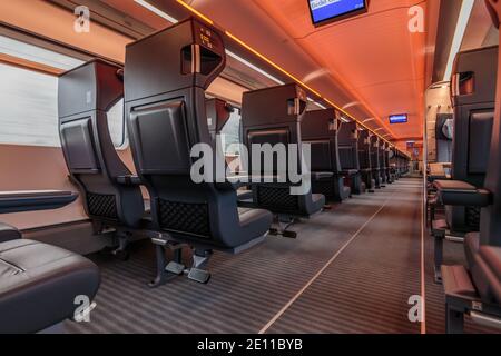 Vue de la première classe des chemins de fer allemands. Vider les sièges dans le compartiment voiture. Personne dans le train. Allée centrale avec éclairage pendant la conduite Banque D'Images