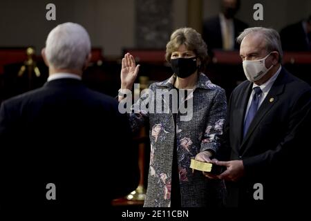 Washington, États-Unis. 03ème janvier 2021. La sénatrice Jeanne Shaheen, démocrate du New Hampshire, au centre, porte un masque protecteur tout en étant officiellement assermentée par le vice-président américain Mike Pence, parti, avec le mari Bill Shaheen au Capitole des États-Unis à Washington, DC, le dimanche 3 janvier 2021. Le 117e Congrès commence aujourd'hui avec l'élection du Président de la Chambre et l'administration du serment d'office des législateurs dans les deux chambres, des procédures qui seront modifiées pour tenir compte des précautions Covid-19. Photo de piscine Samuel Corum/UPI crédit: UPI/Alamy Live News Banque D'Images