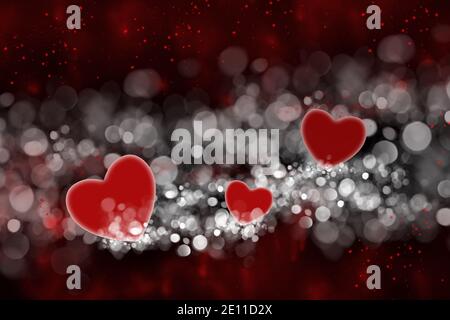 Coeurs rouges et bokeh blanc sur fond noir. Saint Valentin. Un arrière-plan romantique et abstrait. Banque D'Images