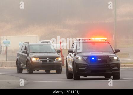 Saint John, N.-B., Canada - le 11 novembre 2020 : voiture de police qui roule sur une route avec ses feux allumés. Un vus se déplace derrière la voiture de police. Banque D'Images