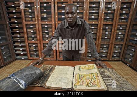 Le Junior Director Mohamed Touré présente des manuscrits dans la bibliothèque privée Mamma Haidara à Tombouctou, Mali, Afrique de l'Ouest. Banque D'Images