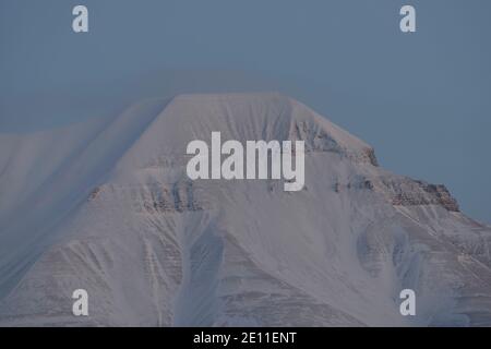 Hiver sombre sur Svalbard. Montagne Hiorthfjellet au crépuscule en février, Adventfjorden, Longyearbyen, Spitsbergen, Svalbard, Norvège Banque D'Images