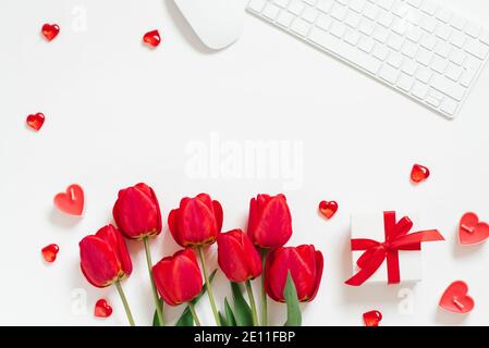 Flat Lay Valentines Day fond avec clavier d'ordinateur, cadeau, tasse à café et tulipe rouge vue du dessus espace copie blanc Banque D'Images