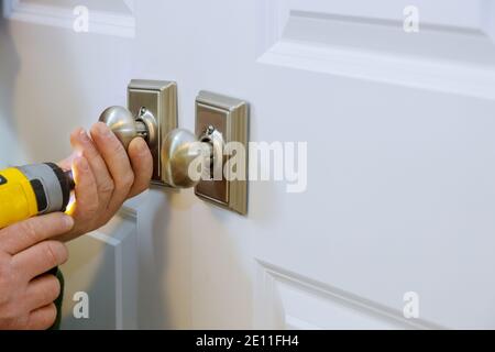 Master avec tournevis installe accéder à la porte de la salle nouveau faux verrou dans la maison. Banque D'Images