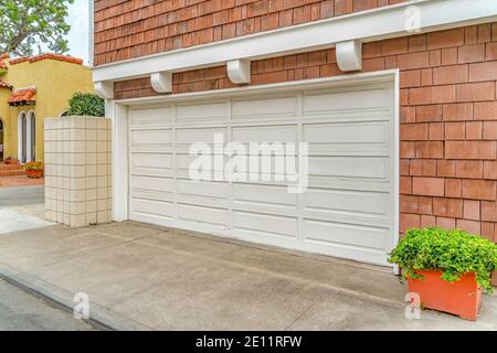 Porte blanche de garage de deux voitures de maison avec bardeaux revêtement sur le mur extérieur Banque D'Images