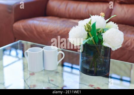 Deux tasses de thé ou de café sur un café table dans une pièce intérieure lumineuse Banque D'Images