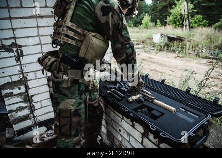 Le soldat tire une carabine hors de la boîte de munitions et insérer le clip de munitions dans le fusil d'assaut Banque D'Images