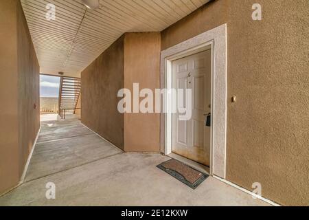 Entrée à la maison au premier étage d'un immeuble d'appartements avec porte avant blanche Banque D'Images