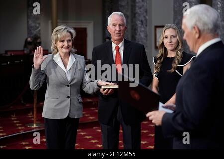 La sénatrice des États-Unis Cindy Hyde-Smith (républicaine du Mississippi), rejointe par son mari Mike Smith et sa fille Anna-Michael Smith, se présente sous le serment du vice-président Mike Pence lors d'une cérémonie de reconstitution dans l'ancienne salle du Sénat au Capitole à Washington, le dimanche 3 janvier 2021. Crédit : J. Scott Applewhite/Pool via CNP/MediaPunch Banque D'Images
