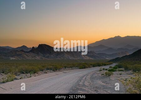 Route de terre à travers le désert, et dans les montagnes brumeuses près d'Uspallata, Mendoza, Argentine. Banque D'Images