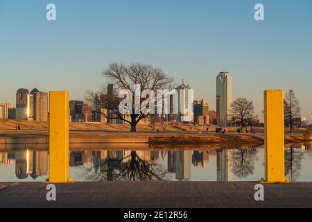 Les gens se détendent au parc de Trammel Crow avec une vue sur les gratte-ciel de Dallas, au Texas, en arrière-plan et un étang réfléchissant au premier plan. Banque D'Images