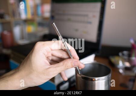 Paille à boire en acier inoxydable réutilisable à la main Banque D'Images