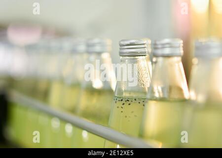 Les bouteilles de boisson sont transportées sur un convoyeur dans un usine de production Banque D'Images