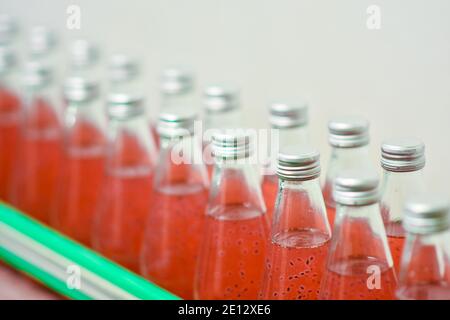 Les bouteilles de boisson sont transportées sur un convoyeur dans un usine de production Banque D'Images