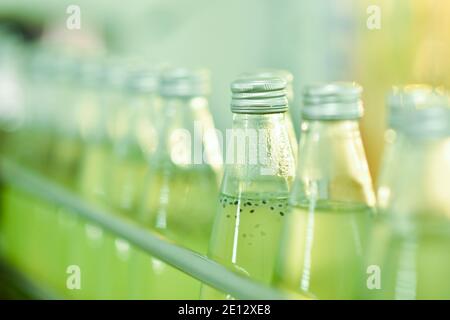 Les bouteilles de boisson sont transportées sur un convoyeur dans un usine de production Banque D'Images