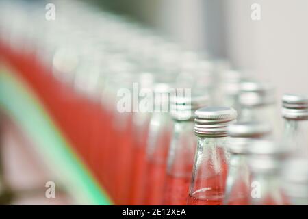 Les bouteilles de boisson sont transportées sur un convoyeur dans un usine de production Banque D'Images