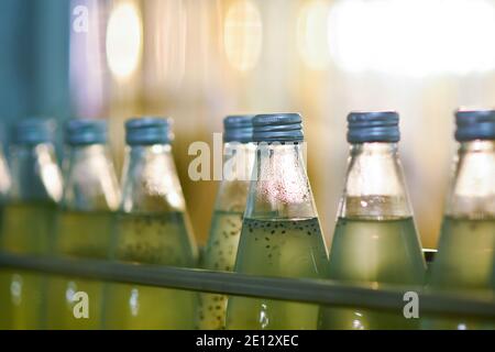 Les bouteilles de boisson sont transportées sur un convoyeur dans un usine de production Banque D'Images