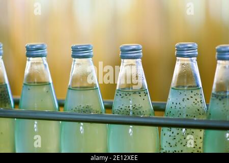 Les bouteilles de boisson sont transportées sur un convoyeur dans un usine de production Banque D'Images