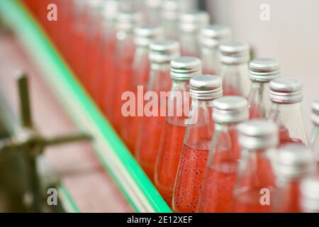 Les bouteilles de boisson sont transportées sur un convoyeur dans un usine de production Banque D'Images