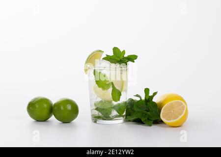 vue sur un cocktail mojito rafraîchissant entouré de limes, de citrons et de feuilles de menthe fraîche Banque D'Images