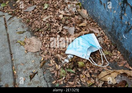 Masque utilisé jeté dans la rue Banque D'Images