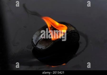 Gravure de la souris d'un ordinateur sans fil sur une table noire. Gros plan d'un ordinateur portable ou d'un dispositif de commande informatique sur le feu.concept de sécurité incendie. Banque D'Images