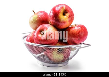 pommes rouges mûres dans une passoire sur fond blanc Banque D'Images