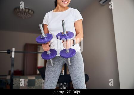 Une femme musclée qui fait de l'exercice avec des poids pour les mains Banque D'Images