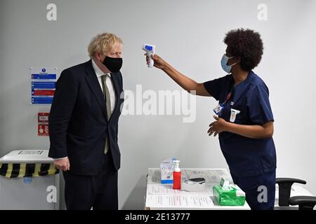 La température du Premier ministre Boris Johnson est vérifiée lors d'une visite à l'hôpital Chase Farm, dans le nord de Londres, le jour où le NHS augmente son programme de vaccination avec 530,000 doses du nouveau jab de vaccin Covid-19 d'Oxford/AstraZeneca, qui peut être déployé dans tout le Royaume-Uni.