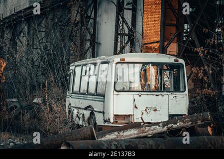 Vieux bus abandonné rouillé dans un paysage post-apocalyptique industriel sombre. Banque D'Images