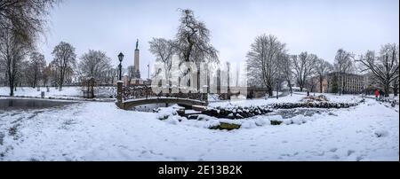 Paysage hivernal panoramique dans un parc enneigé avec beau pont sur un petit étang, lumière de la rue et couvert de neige. Vue sur le parc de Bastion Hill Banque D'Images