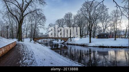 Paysage hivernal panoramique dans un parc enneigé avec beau pont sur un petit canal, lumière de la rue et couvert de neige. Vue sur le parc de Bastion Hill Banque D'Images