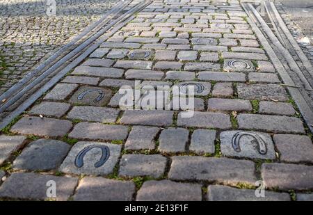 Berlin, Allemagne. 08 décembre 2020. Une voie ferrée intégrée dans le trottoir de Reichenberger Straße, entre laquelle des fers à cheval sont embarqués, est destinée à montrer que le Grand Berlin Horse Railway a couru ici. Divers projets d'art visent à rappeler aux gens le passé industriel de la rue. Credit: Britta Pedersen/dpa-Zentralbild/ZB/dpa/Alay Live News Banque D'Images