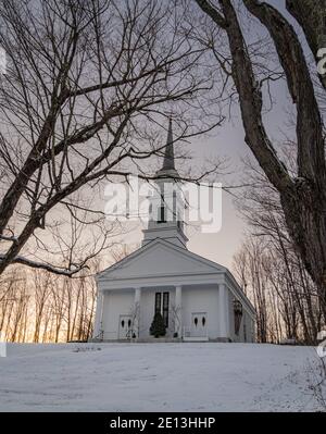 Classique Nouvelle-Angleterre église blanche sur le village vert sur un soirée d'hiver Banque D'Images