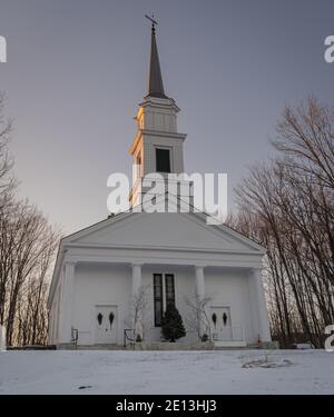 Classique Nouvelle-Angleterre église blanche sur le village vert sur un soirée d'hiver Banque D'Images