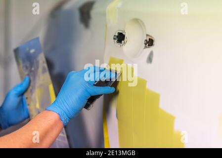 Préparation pour la peinture d'une voiture à l'aide de l'élément capteur d'émeri par un technicien de nivellement avant l'application d'un primaire après l'endommagement d'une partie de la Banque D'Images