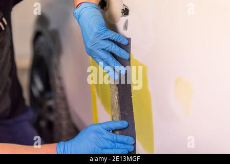 Préparation pour la peinture d'une voiture à l'aide de l'élément capteur d'émeri par un technicien de nivellement avant l'application d'un primaire après l'endommagement d'une partie de la Banque D'Images