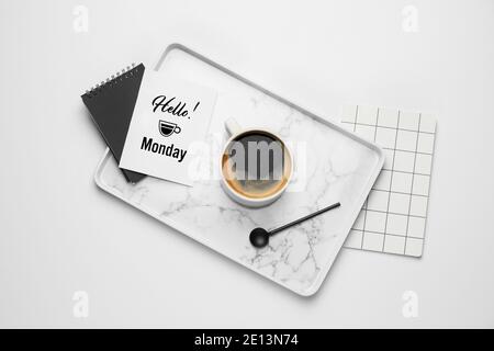Composition avec tasse de café et carte de vœux avec texte BONJOUR LUNDI sur fond blanc Banque D'Images