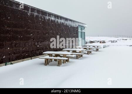 Vue sur le centre d'information et les tables enneigées de la vallée du Rift du parc national de Thingvellir pendant une tempête de neige en hiver, au sud-ouest de l'Islande Banque D'Images