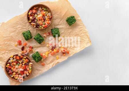 Légumes surgelés dans des bols sur fond blanc Banque D'Images