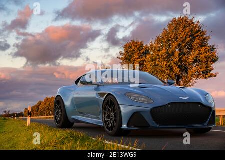 Aston Martin DBS superleggera sur une route pittoresque au coucher du soleil Banque D'Images