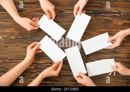 Les gens mains avec des papiers vierges sur fond en bois Banque D'Images