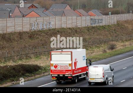 Shepshed, Leicestershire, Royaume-Uni. 4 janvier 2021. Un camion NHS passe devant les graffitis sur le thème du coronavirus à côté de l'autoroute M1. Credit Darren Staples/Alay Live News. Banque D'Images