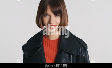 Jolie fille de brune avec bob cheveux vêtus de style décontracté heureux isolé sur fond blanc Banque D'Images