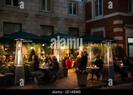 Les gens s'assoient à l'extérieur du restaurant Ivy socialement distancé pendant les restrictions de pandémie de coronavirus jusqu'à Noël 2020, Londres, Angleterre. Banque D'Images