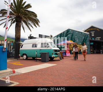 Woodstock, The Old Biscuit Mill- Cape Town, Afrique du Sud- 14/11/2020 Groupe de femmes qui marchent devant une fourgonnette rétro bleue. Banque D'Images