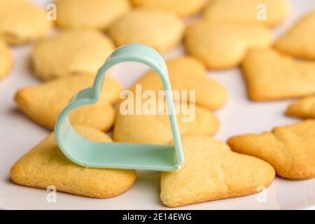 Petits gâteaux faits maison pour la Saint-Valentin avec moule à pâtisserie en plastique vert. Banque D'Images