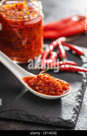 Pâte de piment rouge dans une cuillère en céramique. Banque D'Images