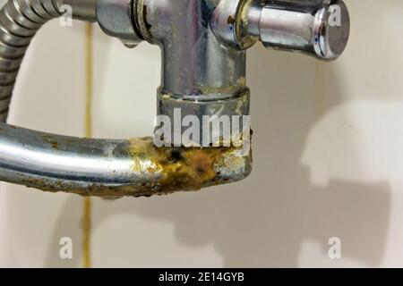 Ancien mélangeur d'eau domestique recouvert de rouille et de tartre. Banque D'Images